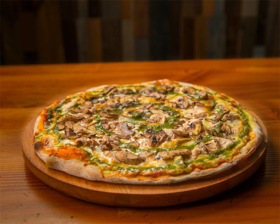 Pizza Amelia — Base pomodoro, mozzarella, pollo, salsa mostaza miel, champiñones y pesto de albahaca.