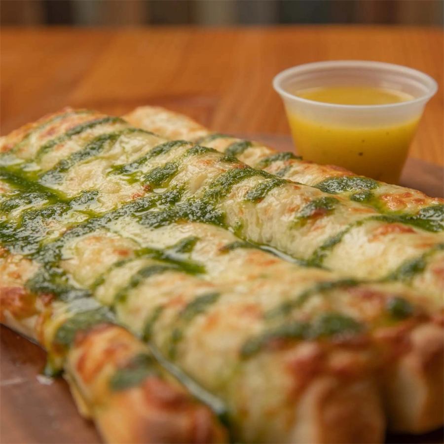 Pizza Bastones de Ajo Parmesano — Bastones de masa fresca con mantequilla de ajo, mozzarella, parmesano y pesto de albahaca. 5 unidades.