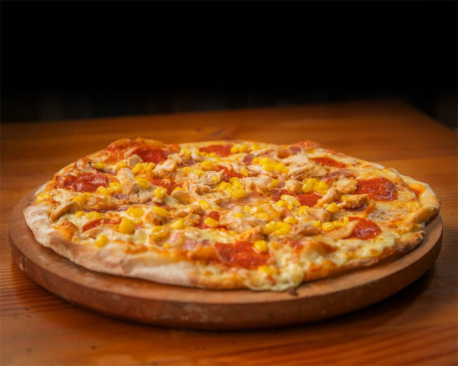 Pizza Gertrudis — Base pomodoro, mozzarella, tocino asado, pollo, pepperoni y choclo.