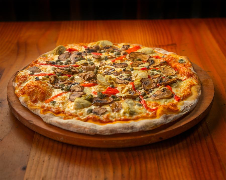 Pizza Giannina — Base pomodoro, mozzarella, alcaparras, pimentón rojo, champiñones y fondos de alcachofa.