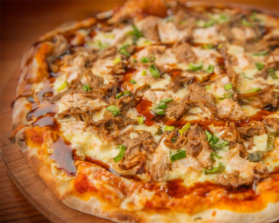 Pizza Giovanna — Base pomodoro, mozzarella, pollo, carne mechada, cebollín y salsa de ostras.