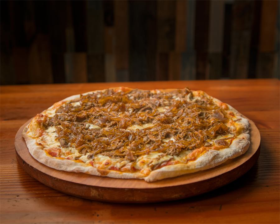 Pizza María — Base pomodoro, mozzarella, carne mechada, cebolla caramelizada y merquén aparte.