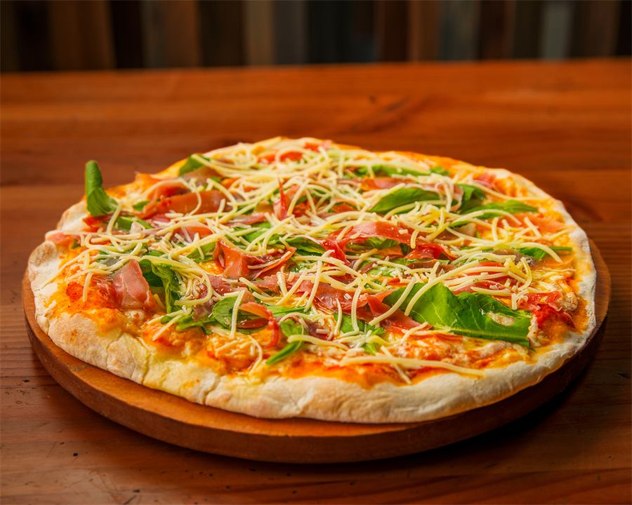 Pizza Sofía — Base pomodoro, mozzarella, jamón serrano, rúcula y toque de parmesano.